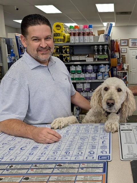 Brandon at the counter with Bentley, his goldendoodle, beside him