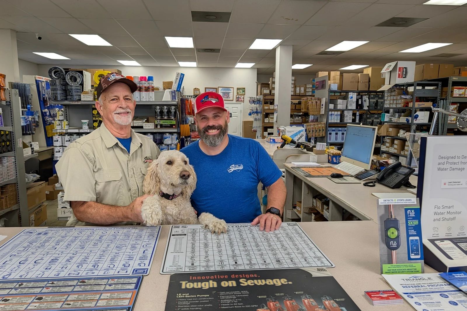 Ricky and Travis at the sales counter with Bentley, the shop dog